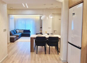 Una sala moderna con un sofá y un comedor con mesa y sillas.