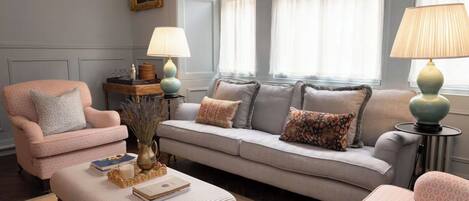 Una sala de estar con un sofá, sillones, una mesa de centro y lámparas.