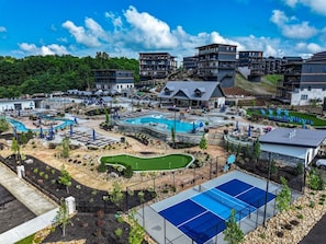 Ein Resort mit mehreren Schwimmbecken, einem Golfplatz und verschiedenen Sitzgelegenheiten im Freien.