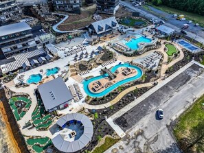 Ein Luftbild zeigt ein Resort mit mehreren Schwimmbecken, einem Golfplatz und einem großen Parkplatz.