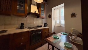 Uma cozinha com armários de madeira, fogão, pia e mesa de jantar com pratos.