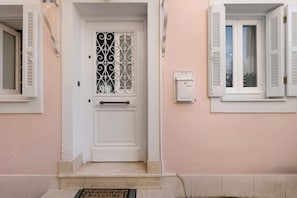 A white door with a decorative metal grille, a small step leading to the entrance, and a doormat with the word 'WELCOME'. - Casabella Apartment in Corfu Town with Air Conditioning (Corfu)