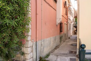 A narrow alleyway with a building on one side and a tree on the other. - Casabella Apartment in Corfu Town with Air Conditioning (Corfu)
