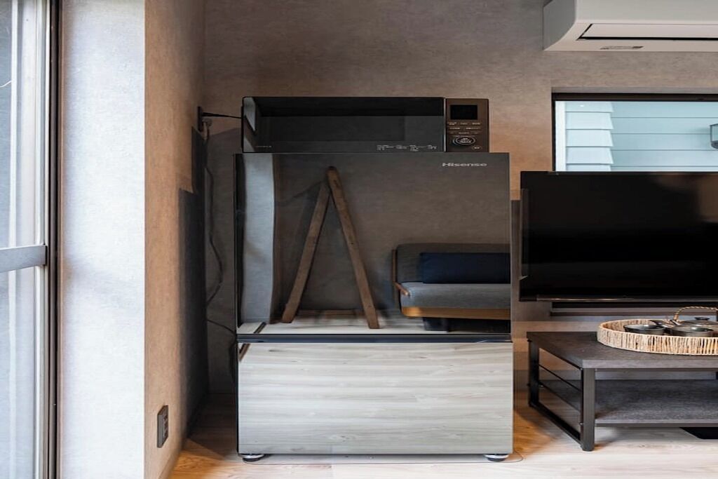 A compact living space with a modern kitchenette, a flat-screen TV, and a minimalist design.
