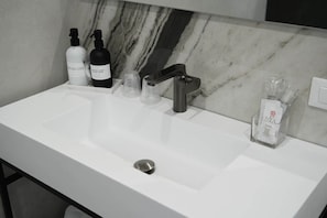 A bathroom with a white sink, a mirror, and toiletries including a bottle of hand soap and a bottle of shampoo. - Superior Double Room (Rome)