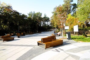 Un parc avec des bancs et un chemin piétonnier dallé.