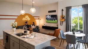 Un espai de vida modern amb una illa de cuina, zona de seients i taula de menjador.