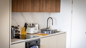 Eine kleine Küche mit Toaster, Wasserkocher und Spüle.