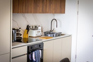A compact kitchen with a toaster, a kettle, and a sink. - Birmingham City Retreat No 146 (Birmingham)