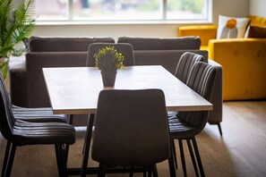 A dining area with a rectangular table, six chairs, and a potted plant. - Birmingham City Retreat No 146 (Birmingham)