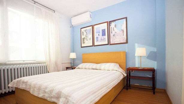 A hotel room with a bed, two bedside tables, a window with curtains, and an air conditioning unit. - Penthouse 4BR Apartment · Terrace · Bosphorus View · Central Beyoğlu (Beyoğlu)