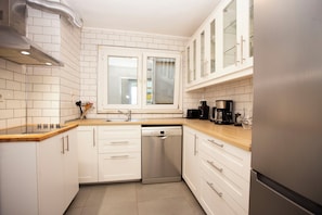 A modern kitchen with white cabinetry, a Bosch dishwasher, and a window above the sink. - Penthouse 4BR Apartment · Terrace · Bosphorus View · Central Beyoğlu (Beyoğlu)