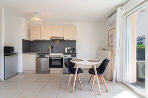 Eine moderne Küche mit Essbereich, ausgestattet mit Backofen, Mikrowelle und Geschirrspüler.