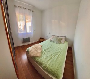 A bedroom with a bed, a window with curtains, a bedside table, and a wall-mounted light. - A cozy villa and spa between the ocean and the Basque Country... Le Clos des Chats Heureux (Saint-Martin-de-Seignanx)