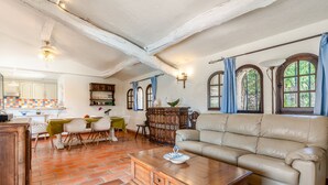 Un ampio soggiorno con un divano in pelle, un tavolino in legno e un'area pranzo con tavolo e sedie.