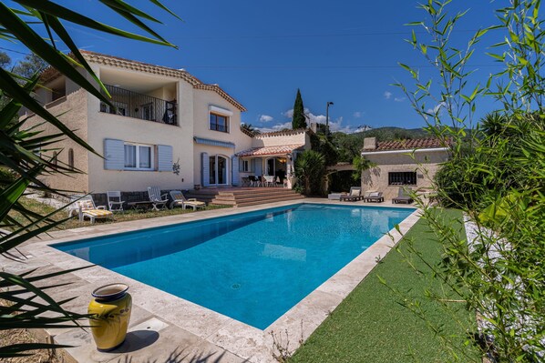 Un bâtiment à deux étages doté d’une piscine, d’un espace extérieur aménagé et offrant une vue sur le paysage environnant.