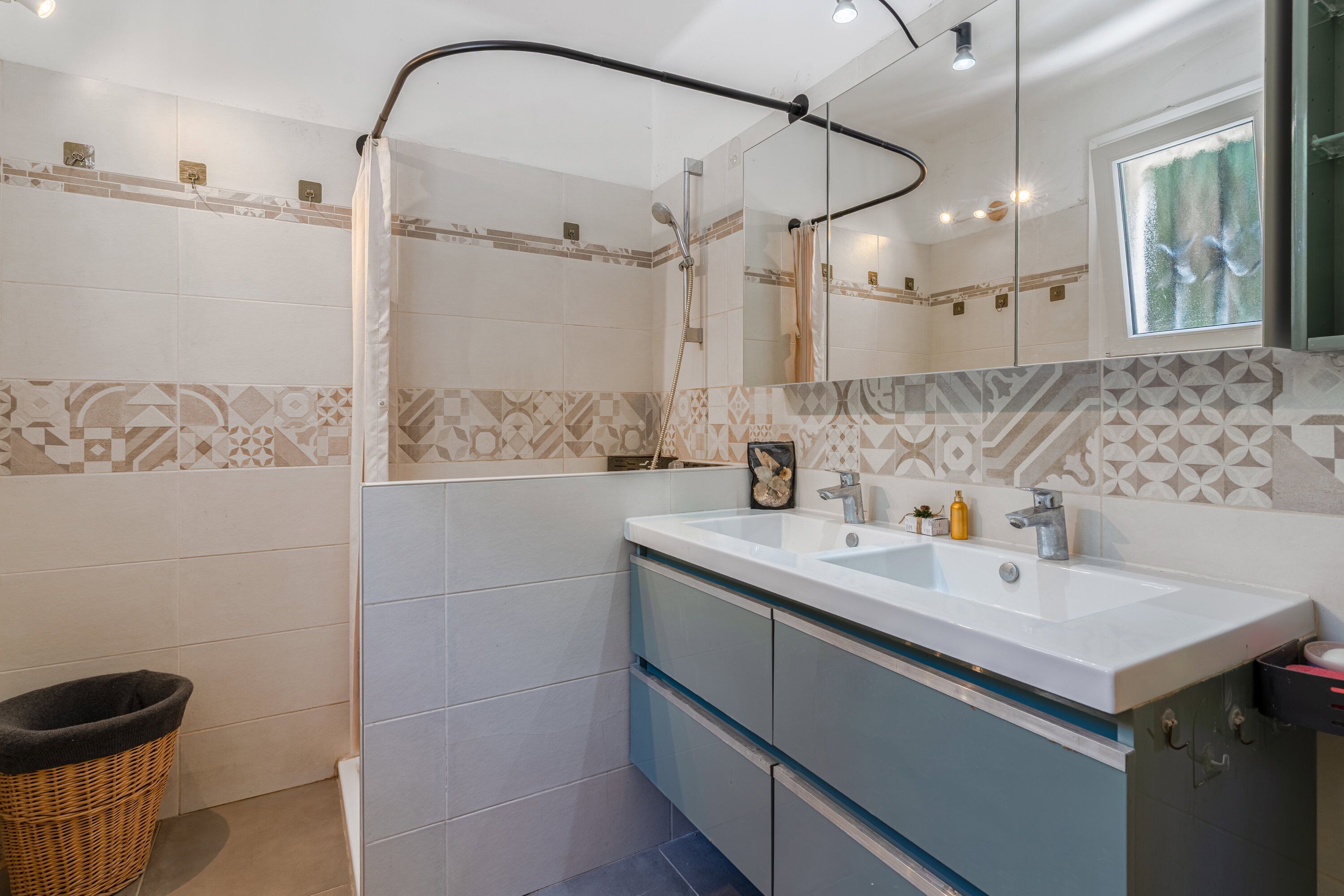 A bathroom with a shower, a sink, and a mirror.