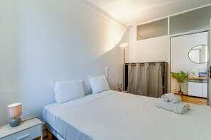Ein Hotelzimmer mit Bett, Nachttisch, Lampe und Spiegel.