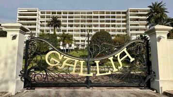 Una entrada protegida con el nombre 'GALLIA' exhibido en una puerta metálica decorativa.