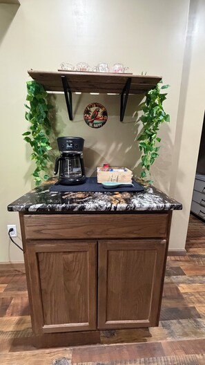 A kitchen island with a coffee maker, a tray, and a decorative sign. - Cozy private space with an outdoor patio, 10 minutes from downtown Asheville (Candler)