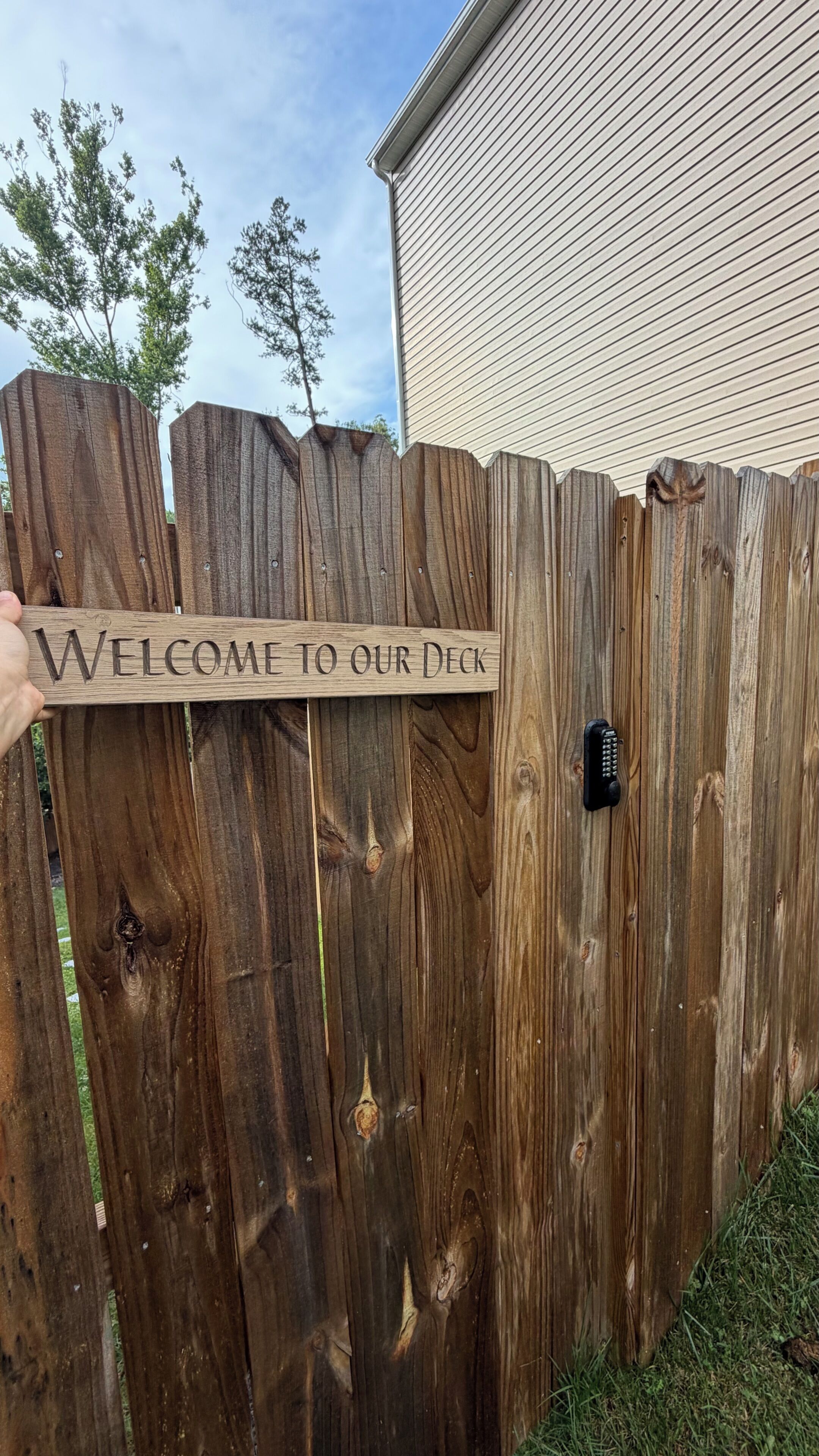 A wooden fence with a welcome sign.