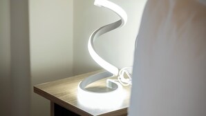 A bed with a white pillow and a bedside table with a white lamp. - Modern Kallithea flat - Metro-AC-WiFI (Kallithea)