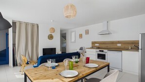 Eine moderne Küche mit weißen Schränken, einer Holz Arbeitsplatte und einem Edelstahl-Kühlschrank.
