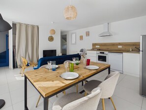 A modern kitchen with white cabinets, a wooden countertop, and a stainless steel refrigerator. - Cozy nest for 4, 400 m from the beach (Dinard)