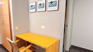 A small room with a wooden desk, a metal chair, and three framed pictures on the wall. - Hotel Centro (Cali)