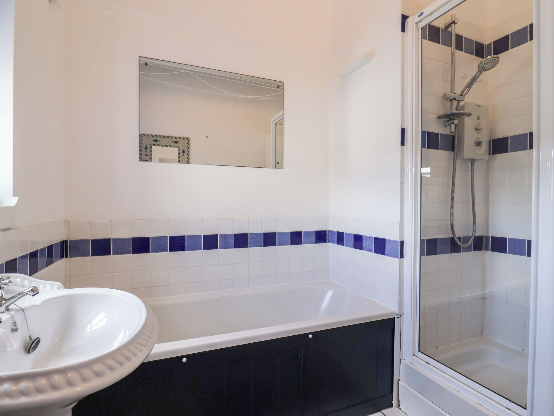 Ein Badezimmer mit Badewanne, Waschbecken und Dusche.