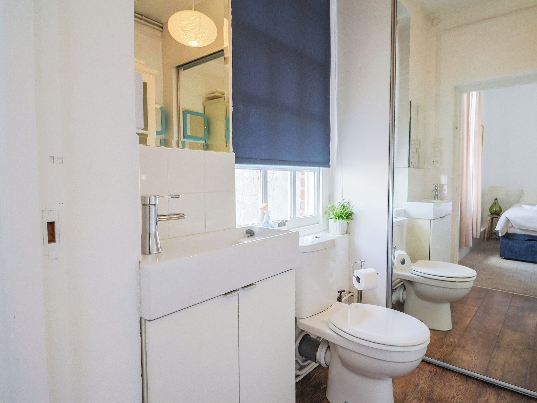 Un baño moderno con inodoro, lavabo y espejo.