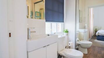 Un baño moderno con inodoro, lavabo y espejo.