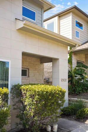 A residential building with a stone facade, a number '9502' on the wall, and a small window. - Modern 2BR Haven near Austin & Tesla (Manor)