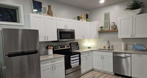 A modern kitchen with white cabinets, stainless steel appliances, and a built-in microwave. - The Last Lake Stop- 2Bedroom Home (Peru)