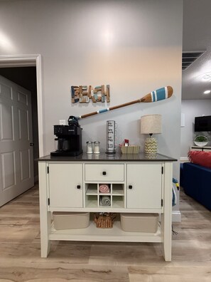 A white cabinet with drawers and shelves, a coffee maker, and decorative items on top. - The Last Lake Stop- 2Bedroom Home (Peru)