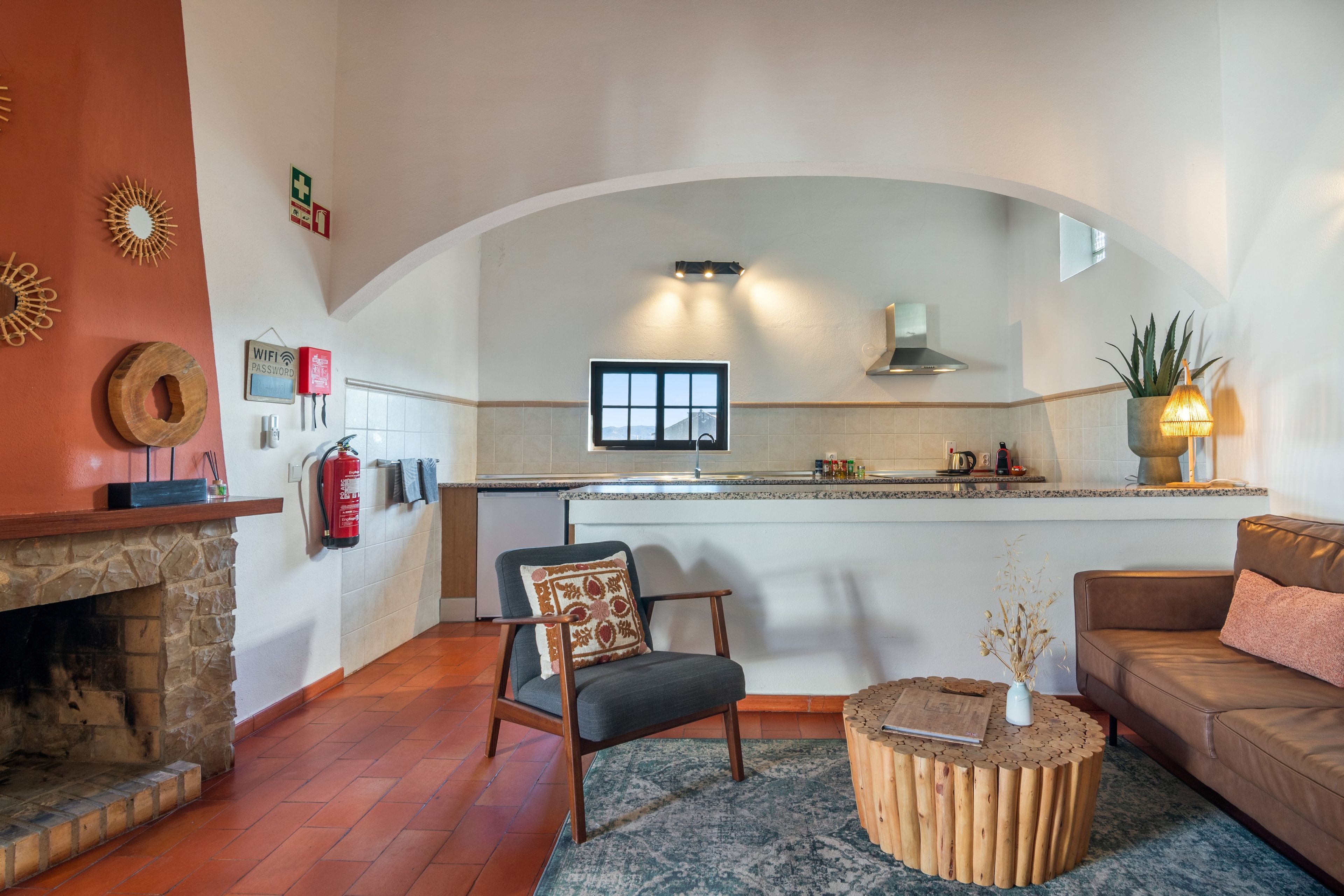Un salon moderne avec une cheminée, un coin repas avec une cuisine en arrière-plan et un espace salon confortable.