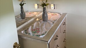Une cuisine équipée d’un réfrigérateur, de deux vases ornés de fleurs et d’un plan de travail recouvert d’une nappe à motifs floraux.
