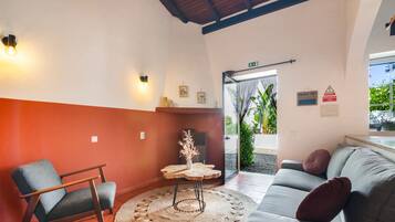 Um interior aconchegante com um sofá, uma poltrona e uma mesa redonda com um objeto decorativo.