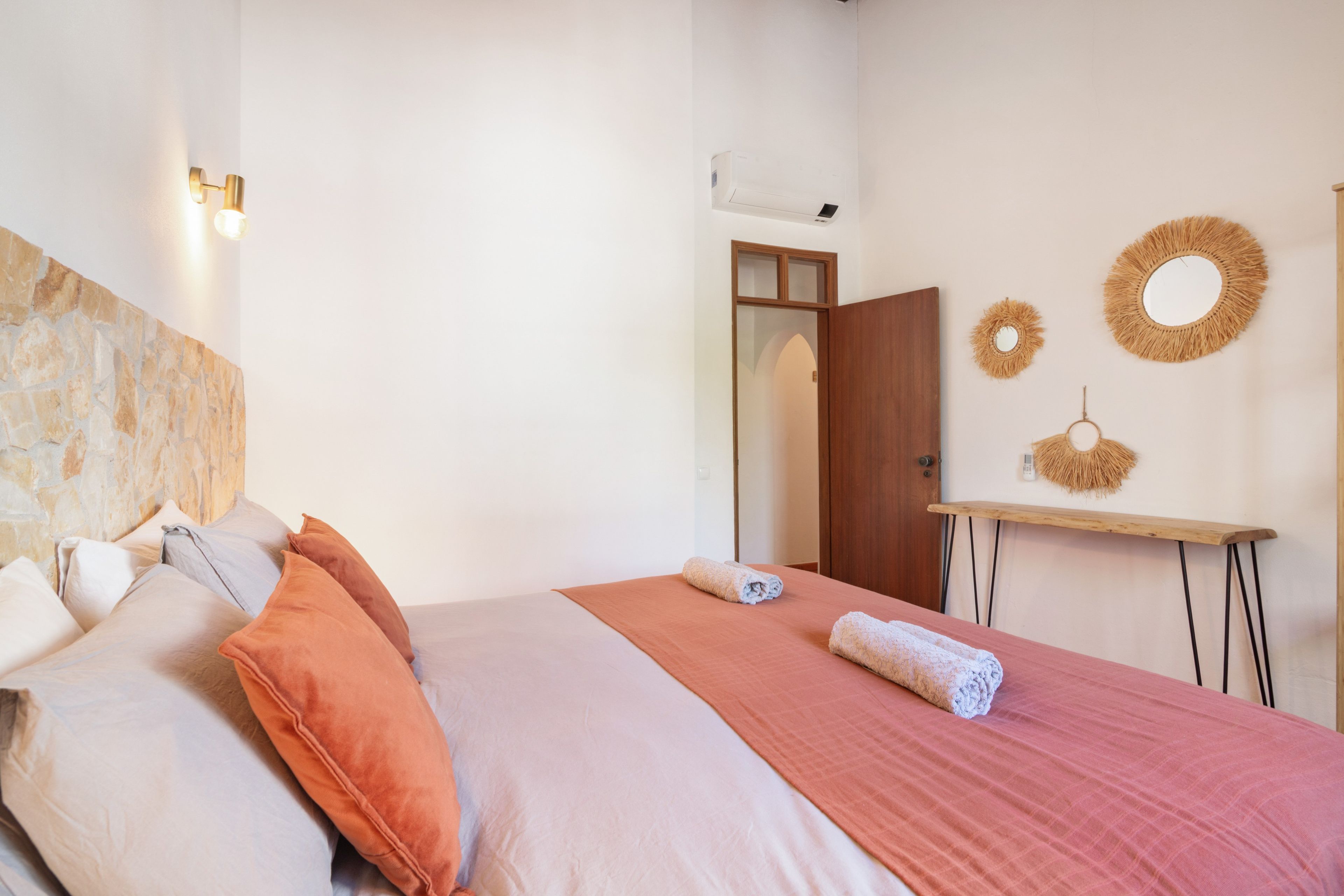 Une chambre d’hôtel avec un lit, des oreillers, une table de chevet et des éléments de décoration murale.