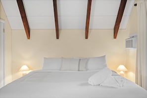 A hotel room with a large bed, two bedside lamps, and an air conditioning unit. - A-Frame Retreat - Hot Tub, Fire Pit & Fireplace (Monroe County)