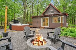 A cabin with a fire pit, outdoor seating, and a hot tub. - A-Frame Retreat - Hot Tub, Fire Pit & Fireplace (Monroe County)