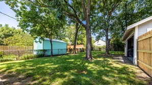 A backyard with a fenced area, a small shed, and a garage. - 7th St Retreat-Tv's in Every Bedroom-Fully Fenced (Tulsa)