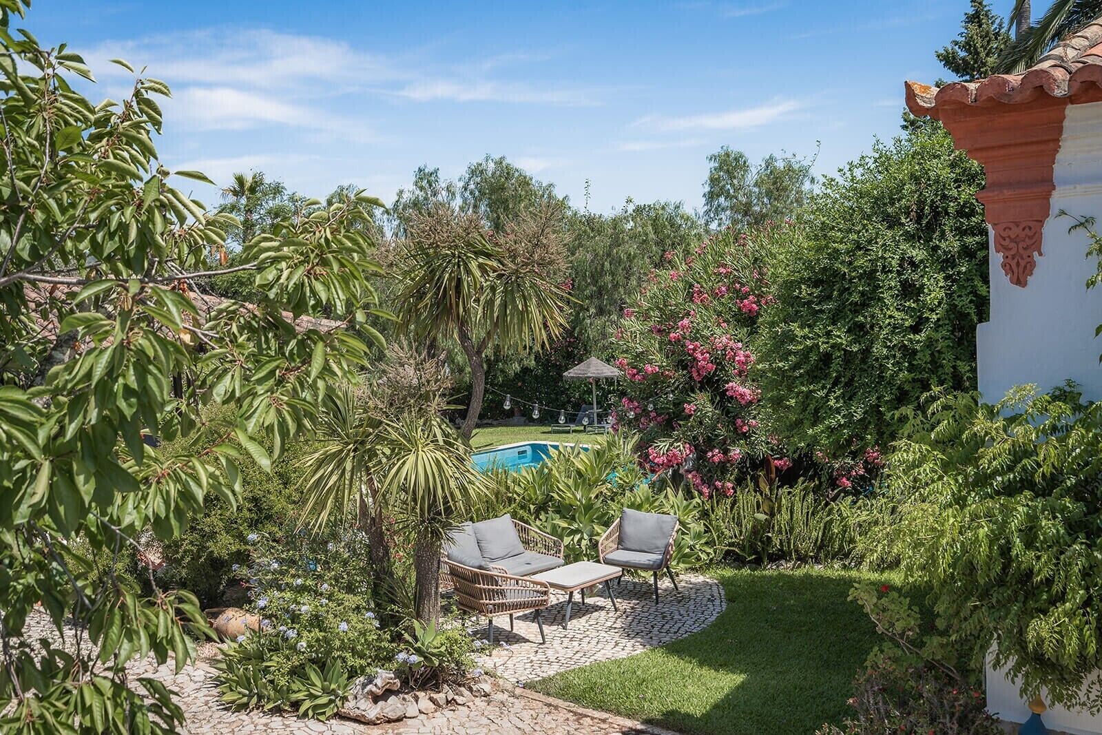Un jardin avec une piscine, un fauteuil de relaxation et un espace aménagé.