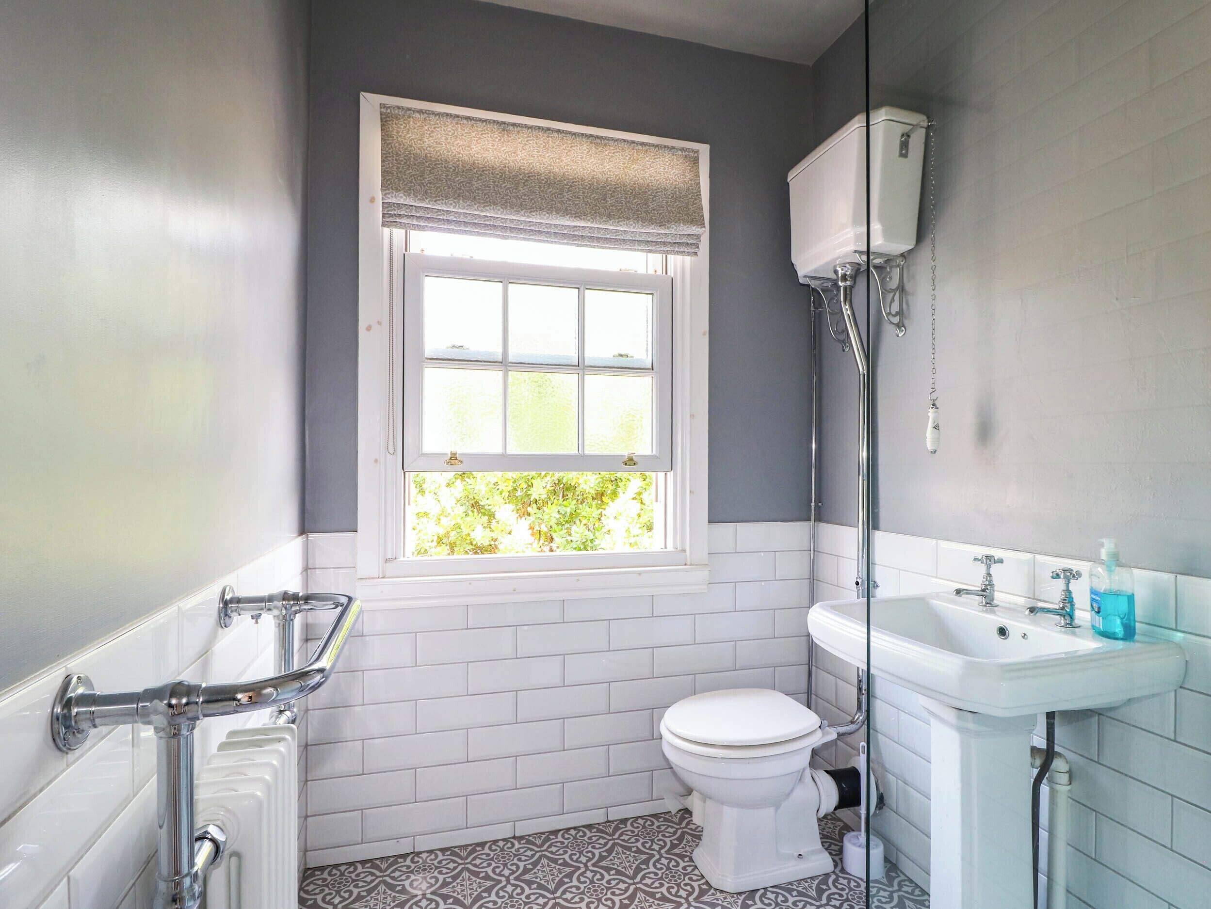 Un baño con inodoro, lavamanos y ventana.