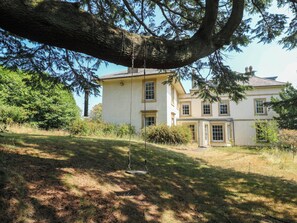 A two-story building with a large tree in the foreground.