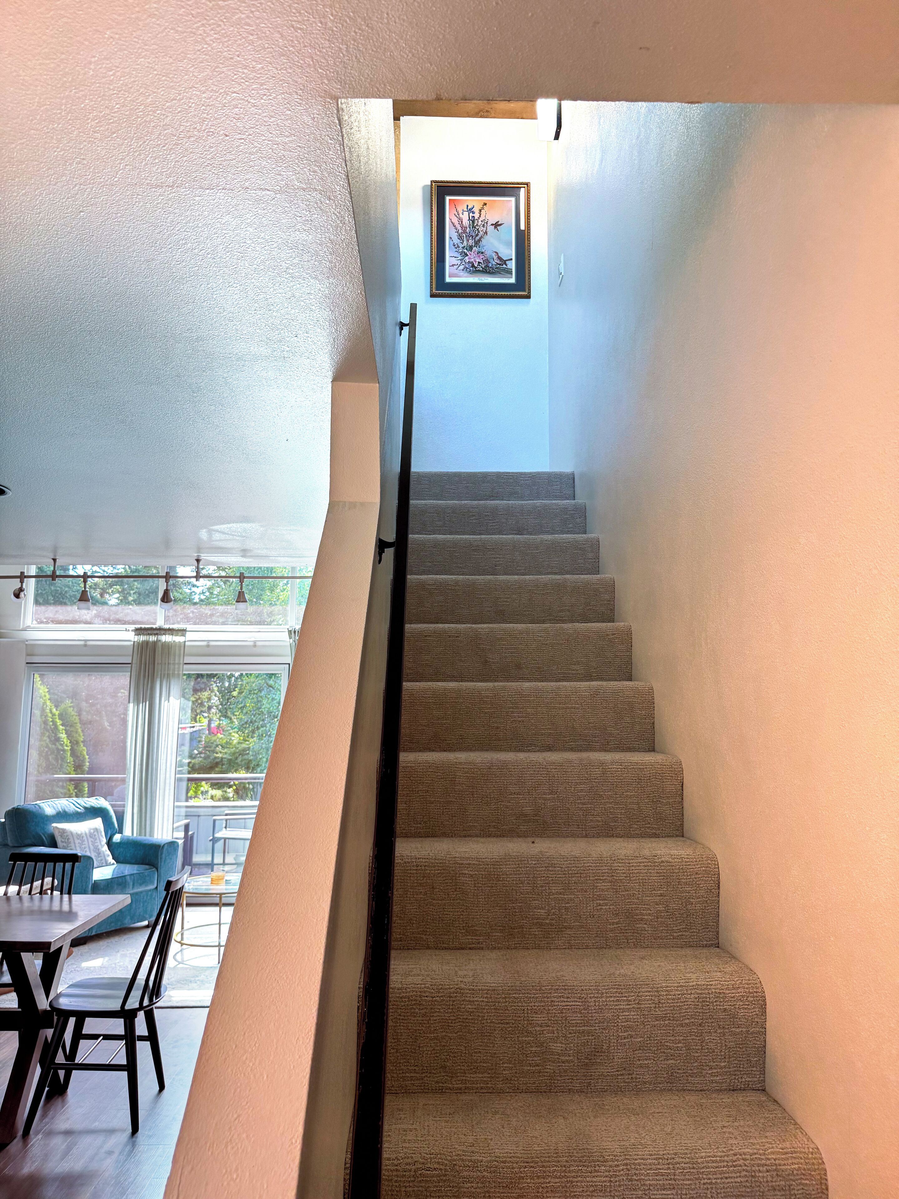 A staircase with carpeted steps leading to a landing.