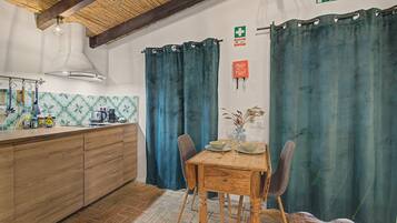 Una cocina con armarios de madera, estufa a gas y una lámpara colgante.