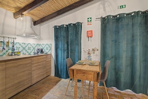 A kitchen with wooden cabinets, a gas stove, and a hanging light fixture. - Holiday Home 'Casa Ferrobo - Lucy' with Shared Pool, Wi-Fi and Air Conditioning (Farrobo)