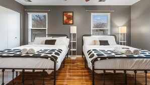 A bedroom with two beds, a ceiling fan, a floor lamp, and a window with blinds. - 
Spacious 4BR Townhouse  Sleeps 13  Near DC&Metro (Arlington)