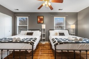 A bedroom with two beds, a ceiling fan, a floor lamp, and a window with blinds. - 
Spacious 4BR Townhouse  Sleeps 13  Near DC&Metro (Arlington)